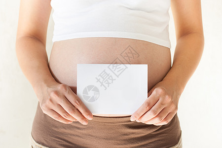 孕妇将手握在肚子上 并举着一刀父母新生活孩子母亲女性母性生育空白怀孕腹部图片