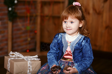 一个可爱小女孩的肖像微笑女孩冒充牛仔裤金发女郎牛仔布夹克礼物盒女性孩子图片