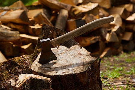 原木和木柴的旧斧头木材木头树桩燃料乐器柴堆橡木木工人刀具金属图片