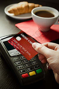 在餐厅使用带有NFC技术的付款终端的男子销售机器金融近场卡片面包顾客咖啡商业电子图片