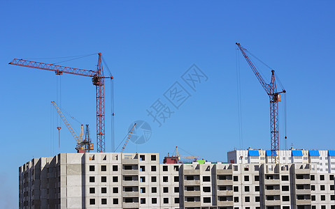 塔吊机工业景观 天空背面有吊机的轮光阴影g蓝色职业住房城市建筑学机器项目风景金属商业背景