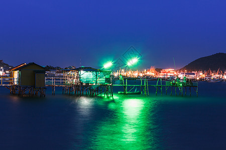 夜间在海上木木屋 有色光海洋旅游地平线太阳蓝色港口人行道假期海景码头图片