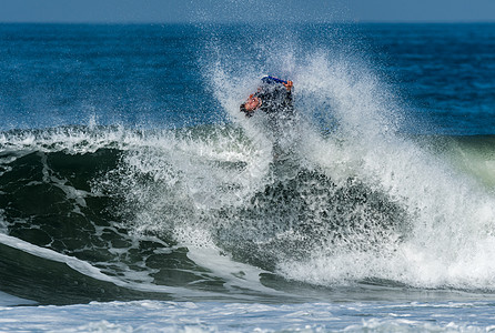机体板手在行动破岸海浪飞溅木板身体趴板乐趣冲浪板肾上腺素蓝色背景图片