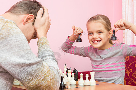 我的女儿很高兴 教皇打过两个棋子 赢了国际象棋图片