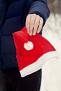 握着圣诞老人帽子的人手紧紧贴上男人庆典微笑快乐礼物季节水平戏服白色工作室图片
