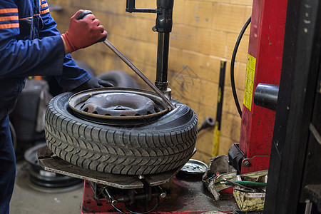 在汽车修理服务中 专业汽车机械师更换轮车轮胎车辆车轮工程师维修技术员阀门成人代品店铺工作图片
