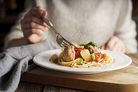 女人用肉丸子吃意大利面餐厅美食午餐女性草本植物时间肉丸盘子营养吃饭图片