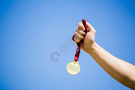 胜利后手握金牌的运动员竞技运动成就丝带能力体育场天空男性奖牌男人图片