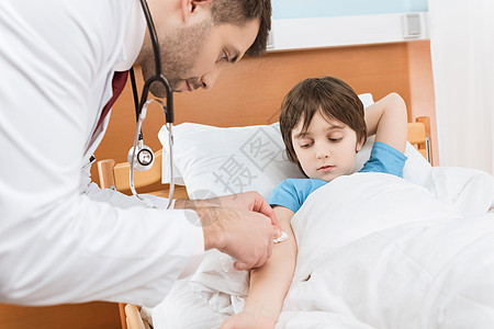 医生身穿医疗制服 对床上的男病人注射卫生男生时代医疗保险药品医院临床少年治疗师疾病图片