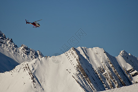 山里的直升机高山旅行岩石季节帮助安全滑雪运动航班天空图片