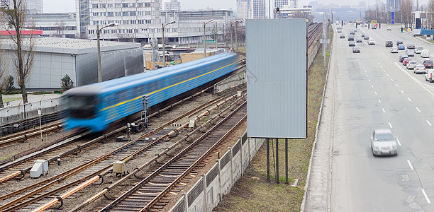 在城市街道旁移动地铁列车和汽车图片