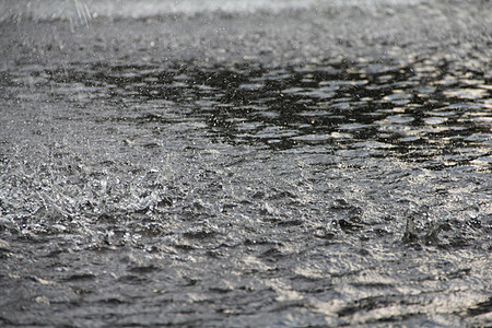 地面大雨雨量飞溅天气波纹淋浴水坑水滴雨滴灰色图片