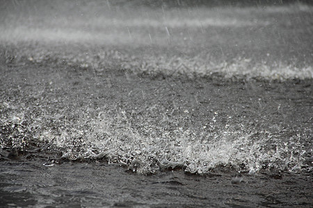 地面大雨雨量水坑灰色飞溅波纹天气雨滴淋浴水滴图片