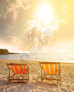 双甲椅在沙滩上 天空飞快图片