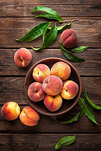 深黑木制生锈背景上有叶子的新鲜果桃树叶乡村红色绿色篮子市场饮食水果桃子营养背景图片