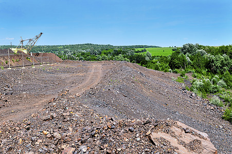采石场挖掘土方工程中的挖掘机石头材料金属河道生态机器植被环境石英岩尾矿图片