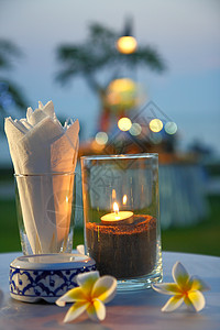蜡烛与白色鸡蛋花和离焦的博克烛光燃烧假期火焰背景节日圆圈烛台季节装饰品图片