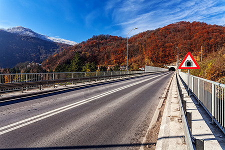 冬季的山桥 有雪和蓝天空国家悬崖交通晴天驾驶爬坡沥青运输基础设施岩石图片