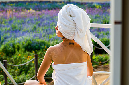 一个穿着浴巾的有纹图的女人 坐在休息室里休息奶油身体治疗护理娱乐奢华温泉享受皮肤图片