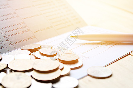 存款账户账簿或财务报表的硬币和笔图片