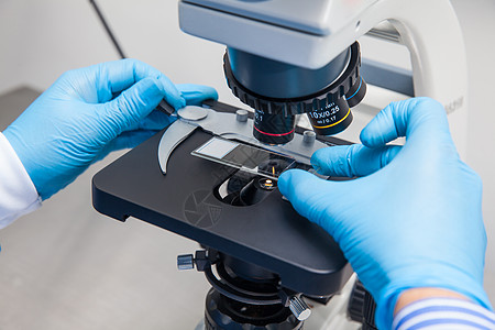 年轻男性科学家 在显微镜下看幻灯片细菌学科学工作微生物学研究员生物手套安全文化技术图片
