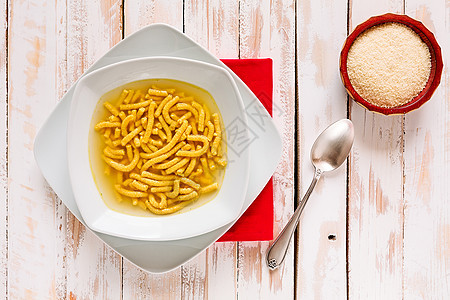 意大利薄汤的意大利皮卡图利水平乡村肉汤午餐红色木头盘子美食餐巾桌子图片