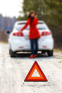 女人站在破碎的汽车旁边 警示三角标志车辆旅行女孩引擎运输帮助失败安全情况维修图片