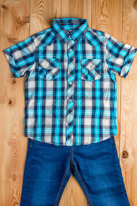 男孩的上层木地板上的蓝衬衫和牛仔裤图片