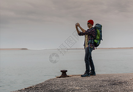 人背包旅行远足者码头远足潮人相机冒险男性地平线自由闲暇年轻的高清图片素材
