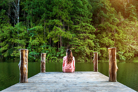 独自坐在湖边木桥上的女孩 泰国的潘阳图片