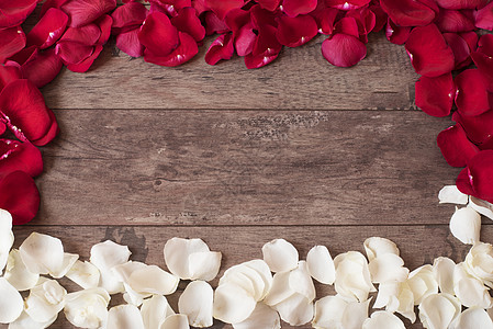 木制背景上的红色和白色玫瑰花瓣 在一张木桌上的玫瑰花瓣边框 顶视图 复制空间 花卉框架 风格营销摄影 婚礼 礼品卡 情人节或母亲图片
