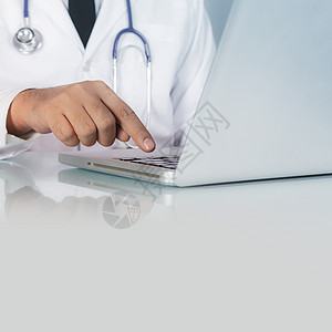 口腔听诊器和笔记本电脑在桌上的医生图片