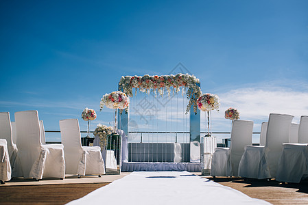婚礼的装饰和结婚仪式的拱门派对宴会花瓣椅子木头庆典环境玫瑰蜡烛海滩图片