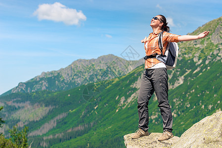 一位快乐的女士用背部征服高山的肖像图片