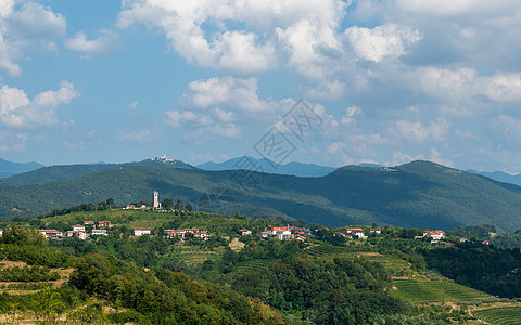 Kojsko 村 斯洛文尼亚著名的葡萄酒产区 背景是阳光和云彩 圣山 背景是新戈里察上方的教堂农业藤蔓建筑学住宅房子葡萄园种植园图片