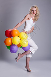 拥有气球的青年妇女红色喜悦成人假期乐趣绿色橡皮紫色玩具白色图片