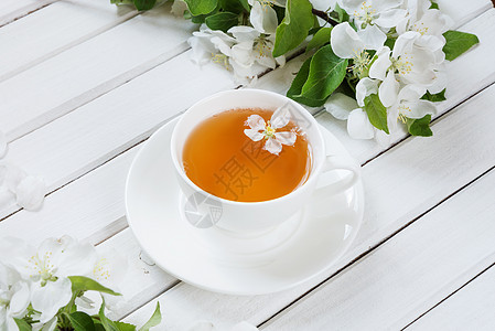 白杯中的绿茶树叶框架插图花瓣杯子桌子苹果树乡村作品木板背景图片