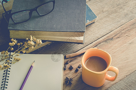木桌上的黄色咖啡杯 配有书籍和眼镜  色调复古食物笔记本早餐铅笔木头咖啡商业桌子办公室图片