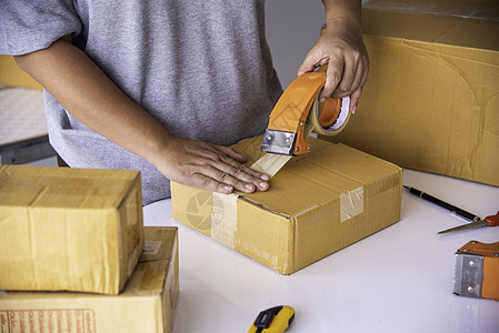 工作人员正在用磁带把包装货物打包运到库斯盒子服务男人送货运输工人搬迁仓库女士开箱图片