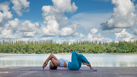 湖边瑜伽亚裔妇女练瑜伽姿势女士天空女性蓝色女孩公园反射地面运动幸福背景