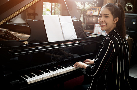 美丽的亚洲女孩学会弹钢琴孩子旋律女性乐器女儿女士学生童年歌曲钢琴家图片
