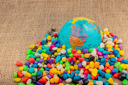 彩色鹅卵石中的小模型地球仪岩石红色宏观地球世界宝石心脏运输矿物碎石图片