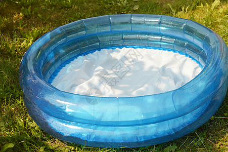 圆形充气儿童游泳池站在夏花园的草地上图片