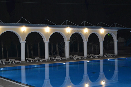 深夜的风景 在豪华的水池中 有柱形和拱门 反映在水中蓝色公寓房子奢华酒店房间躺椅墙壁小屋游泳图片