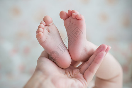 新生婴儿用手抚摸女婴的双脚背景图片