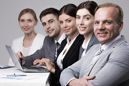 坐在办公室坐在一排排排着的商务人士快乐女士男性男人训练同事研讨会微笑文档商务背景