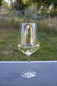 白葡萄酒杯 放在简单的生锈的黑桌子上图片