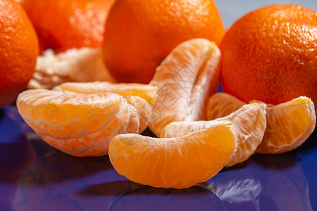 在蓝色盘子上 剥了几个整齐的熟熟橘子水果团体饮食柑桔食物橘味美食生物果汁小吃图片