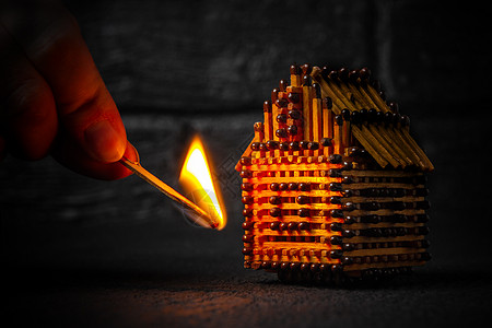 手用燃烧的火柴点燃火柴 风险 财产保险保护或点燃可燃材料概念的房屋模型损害建筑木头玩具预防火灾警告安全火焰灾难图片