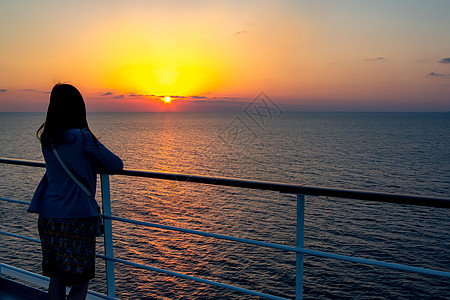 年轻女孩仰慕海面的日落 站在游轮上天空海洋逃离假期巡航日出甲板享受晴天人心图片
